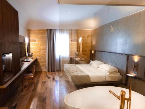 uma casa de banho com uma cama e uma banheira num quarto em Villa Favorita Hotel & Events em Marsala