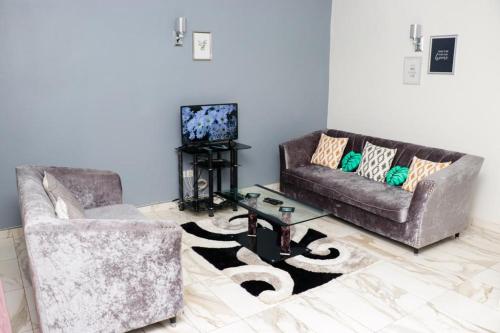 a living room with two couches and a television at ENJOY n RELAX in Douala