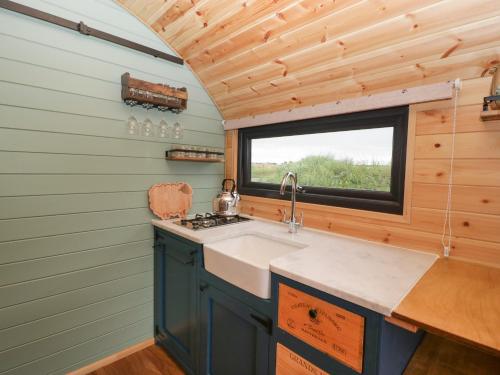 eine Küche mit einem Waschbecken und einem Fenster in der Unterkunft Dew Pond in Blagdon