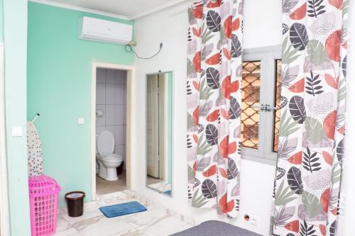 uma casa de banho com um WC e um espelho. em ENJOY n RELAX em Douala