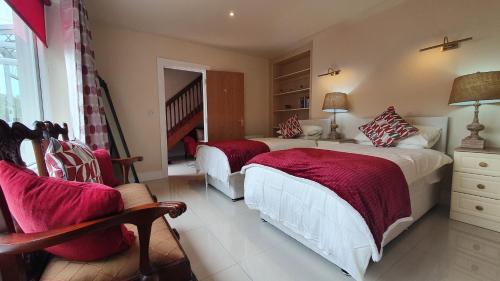 a bedroom with two beds and a chair at The Merry Monk in Ballina