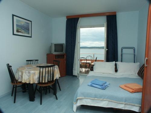 a room with a bed and a table and a window at Apartments by the sea Crikvenica - 2354 in Crikvenica