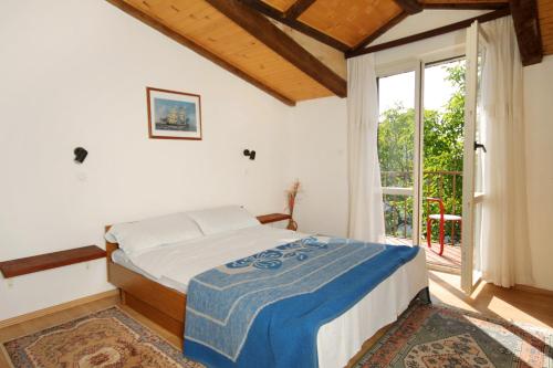 a bedroom with a bed and a large window at Apartments by the sea Selce, Crikvenica - 2372 in Selce
