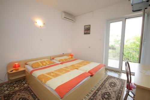 a bedroom with a bed and a large window at Apartment Selce 2379b in Selce