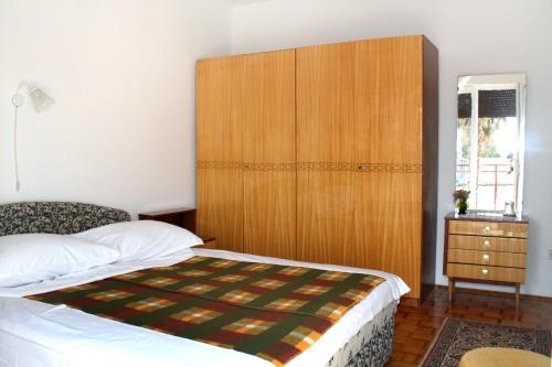 a bedroom with a bed and a large wooden headboard at Double Room Novi Vinodolski 2350a in Novi Vinodolski