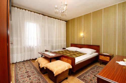 a bedroom with a bed and a table and a desk at Apartments and rooms with parking space Novi Vinodolski - 2350 in Novi Vinodolski