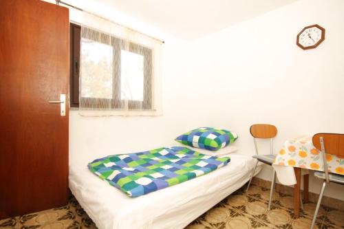 a bedroom with a bed and a table and a window at Studio Brsec 2359a in Brseč