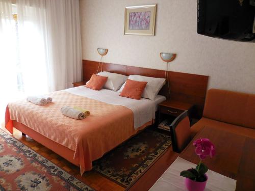 ロヴランにあるRooms with a parking space Lovran, Opatija - 2302のベッドとソファのあるホテルの部屋