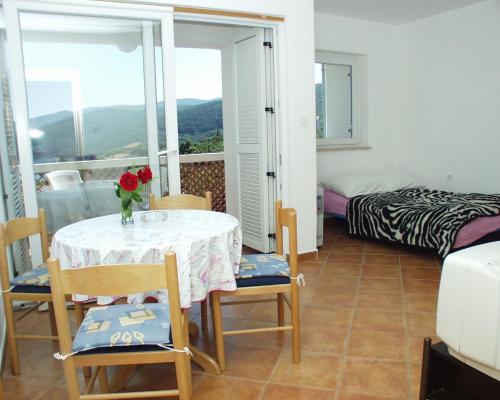 a room with a table and chairs and a bedroom at Apartment Rabac 2323a in Rabac