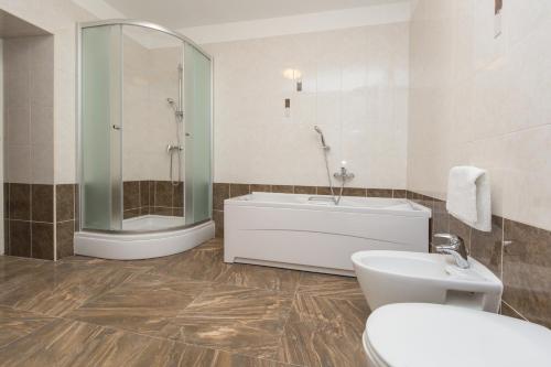 a bathroom with a tub and a toilet and a sink at Apartments by the sea Duga Luka - Prtlog, Labin - 2358 in Drenje