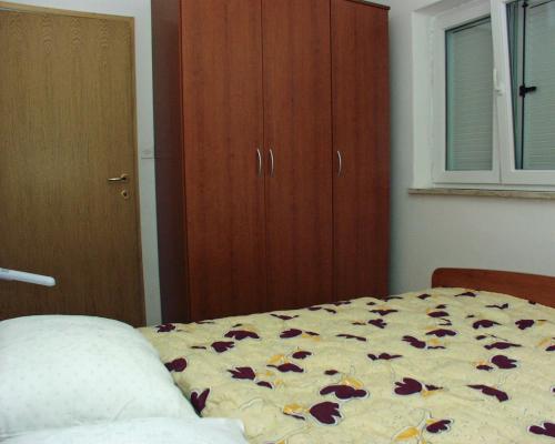 sypialnia z łóżkiem z kwiatami na nim w obiekcie Apartment Rabac 2323b w Rabacu