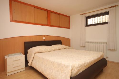 a bedroom with a bed and a window at Apartments by the sea Duga Luka - Prtlog, Labin - 2367 in Drenje