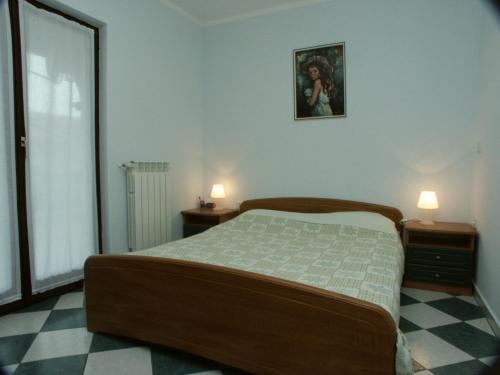 een slaapkamer met een bed en twee nachtkastjes met lampen bij Apartments with a parking space Presika, Labin - 2370 in Labin