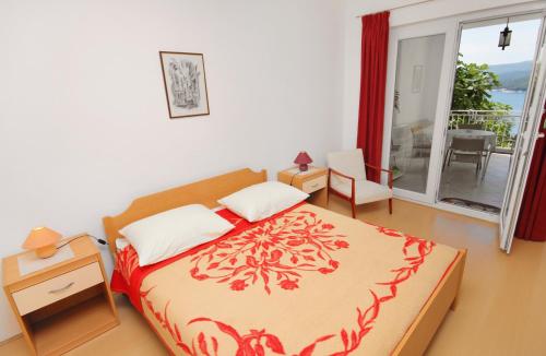 ein Schlafzimmer mit einem Bett und einem Balkon in der Unterkunft Apartments with a parking space Rabac, Labin - 2340 in Rabac