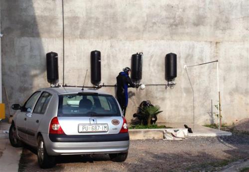 a man standing next to a wall next to a car at Apartments by the sea Sveti Juraj, Senj - 2399 in Sveti Juraj