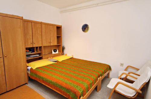 a bedroom with a bed and a cabinet and two chairs at Apartments with a parking space Smrika, Kraljevica - 2365 in Šmrika