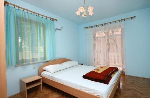 a bedroom with a bed with blue walls and a window at Apartments with a parking space Povile, Novi Vinodolski - 2398 in Povile