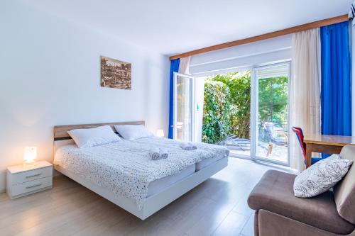 sypialnia z łóżkiem, kanapą i oknem w obiekcie Apartments with a parking space Lovran, Opatija - 2342 w mieście Lovran