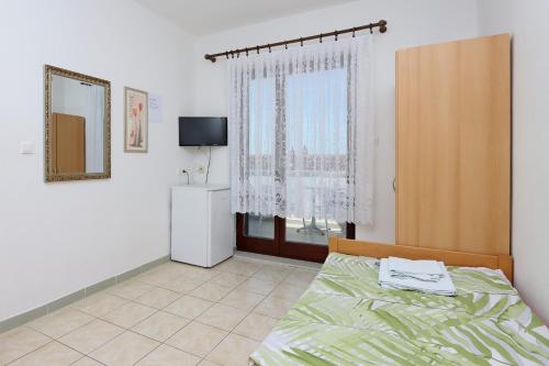 a bedroom with a bed and a tv and a window at Twin Room Selce 2362a in Selce