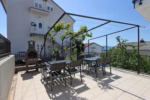 a patio with a table and chairs and a grill at Triple Room Selce 2362c in Selce