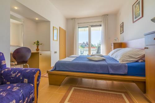 a bedroom with a bed and a chair and a window at Apartments by the sea Selce, Crikvenica - 2356 in Selce