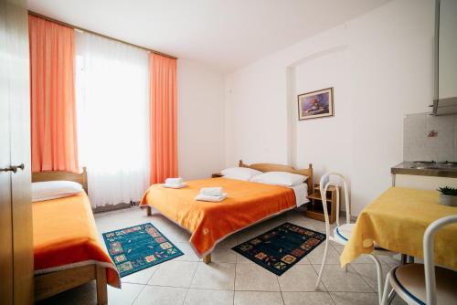 a hotel room with two beds and a window at Studio Selce 2364a in Selce