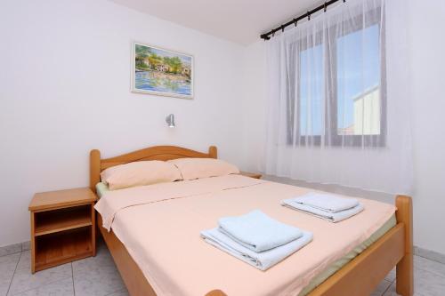 a bedroom with a bed with white sheets and a window at Apartment Selce 2362a in Selce