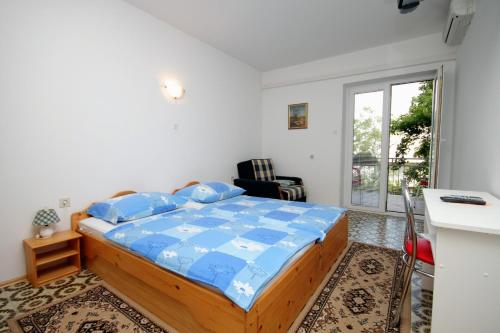 a bedroom with a bed with a blue comforter at Triple Room Selce 2379b in Selce