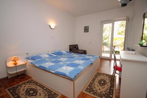 a small bedroom with a bed and a window at Triple Room Selce 2379a in Selce