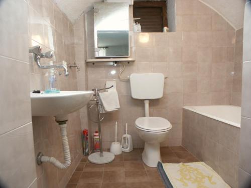 a bathroom with a toilet and a sink and a tub at Studio Novi Vinodolski 2382a in Novi Vinodolski