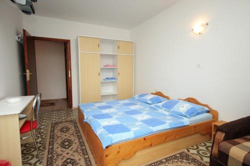 a bedroom with a bed with blue sheets and a table at Triple Room Selce 2379d in Selce
