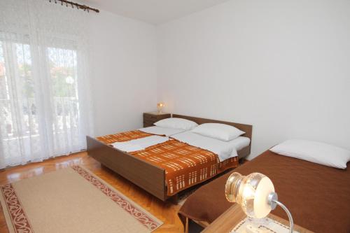 a bedroom with two beds and a table with a lamp at Apartments by the sea Selce, Crikvenica - 2392 in Selce