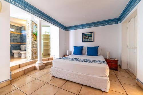 ein Schlafzimmer mit einem Bett mit blauen Kissen darauf in der Unterkunft Villa Osiris in Flic-en-Flac