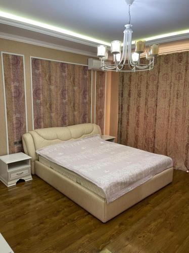 a bedroom with a bed and a chandelier at Villa Qusar in Qusar
