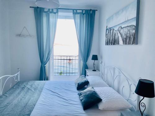 Schlafzimmer mit einem Bett mit blauen Vorhängen und einem Fenster in der Unterkunft Vila Mila Volosko Opatija in Opatija