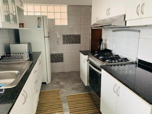 a kitchen with white cabinets and a stove top oven at Spacious apartment in Miraflores in Lima