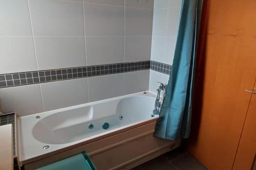 uma banheira na casa de banho com uma cortina de chuveiro azul em Casa Happiness, swimming pool, fast WiFi, parking em Lagos