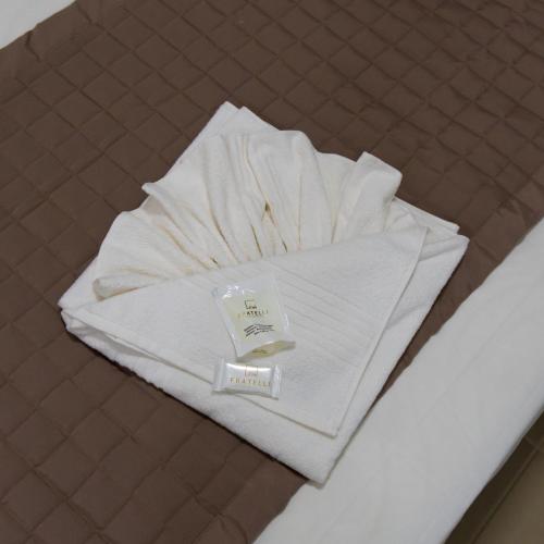 a pile of towels sitting on top of a bed at FRATELLI PREMIUM HOTEL in Elói Mendes