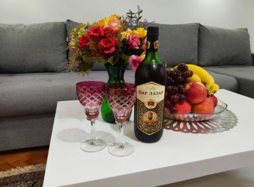 a bottle of wine and two glasses on a table at Palace Luxury Apartments The Heart of Belgrade in Belgrade