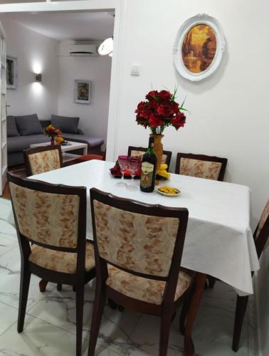 a table with a white table cloth and a vase with flowers at Palace Luxury Apartments The Heart of Belgrade in Belgrade