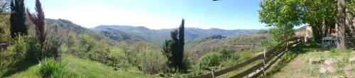 a view of a valley with a fence and mountains at Gîte de Chapelèche Les Châtaigniers in Gluiras