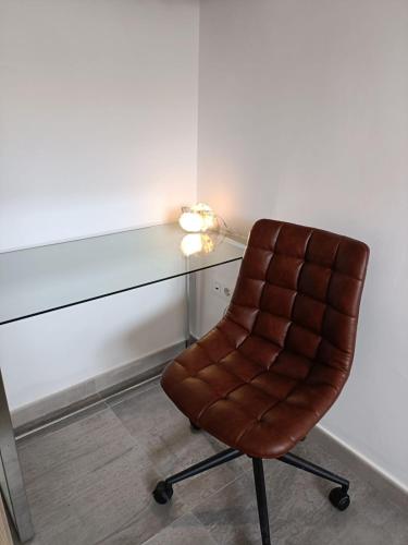 une chaise brune assise à côté d'un bureau avec une lampe dans l'établissement Your home in Gran Canaria, à San Bartolomé
