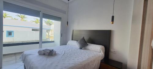 a bedroom with a bed and a large window at La perla blanca in M'diq