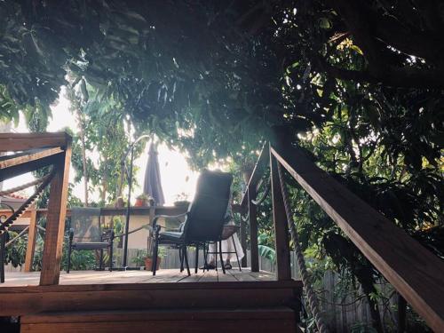 a wooden deck with a chair and a table on it at Private and Comfy Cabin near to MIA airport in Miami