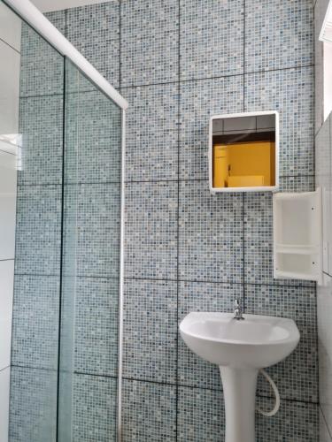 uma casa de banho com um lavatório e um espelho em Maika'i Pousada em Balneário Camboriú