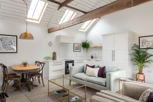 uma sala de estar com um sofá e uma mesa em Linseed Barn- Stamford Holiday Cottages em Stamford