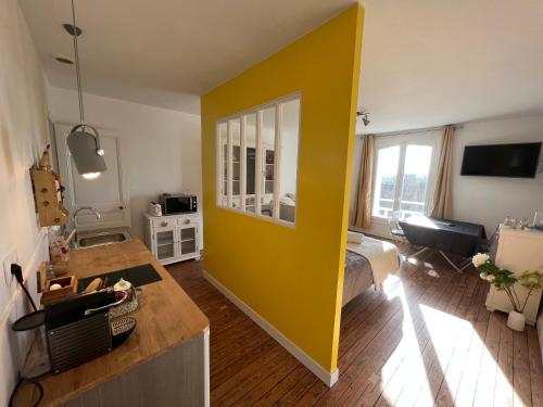 een gele muur in een kamer met een slaapkamer bij Le Manoir des Lys in Tilly-sur-Seulles