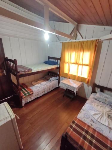 Camera con 2 letti a castello e pavimento in legno. di Pousada Trilha do Farol a Ilha do Mel