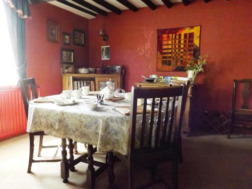 a dining room with a table with a white table cloth at White Cottage Bed and Breakfast in Seisdon