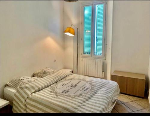 - un petit lit dans une chambre avec fenêtre dans l'établissement Au cœur de Cannes, à l’angle de la rue d’Antibes, à Cannes